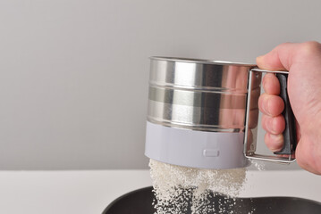 sifter for sifting and aerating flour in the hand of a pastry chef