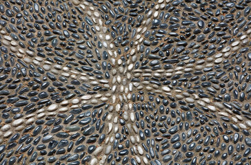 The road is paved with small black and white stones