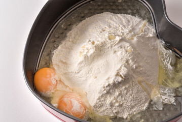 flour and eggs in a cake pan when making dough