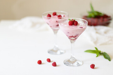 Delicious dessert, cheesecake with fresh raspberries and butter cream mousse in glass. Copy space, flat lay