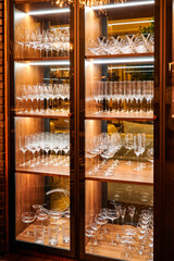 Wooden cabinet with glasses for alcohol in a restaurant