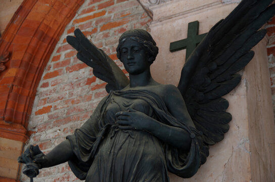 Tombstones and graves, family crypts and vaults on graveyard or cemetery with angels, saints and other statues in winter with snow and lots of symbols and symbolism of eternety and death