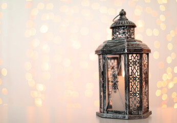 Decorative lantern and blurred lights on background, space for text. Bokeh effect