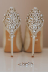 Amazing bridal shoes with diamonds and wedding rings setup. 