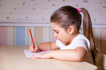 little girl at home writes draws, classes for a child at home   