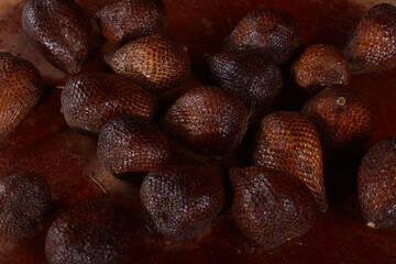 pile of fresh salak fruit with wooden background, fruit photo concept.