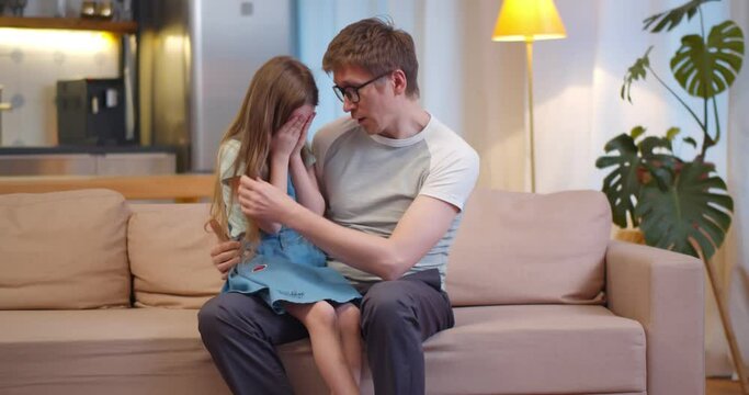 Loving dad comforting crying kid daughter and showing empathy