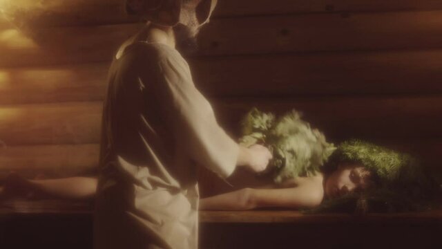 Bath Attendant Makes Spa Massage With Oak Brooms To Boy In Russian Steam Sauna