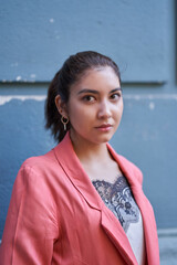 A beautiful Latina white woman on an old background of a blue building