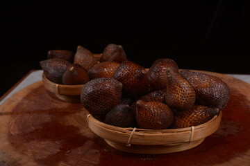 pile of fresh zalacca fruit on a black background