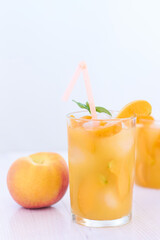 Ripe apricots and glass of apricot juice over white wood background