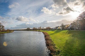 Fototapeta na wymiar view from bride to dike and beautiful werdersee, a river in bremen, in the sun with amazing sky