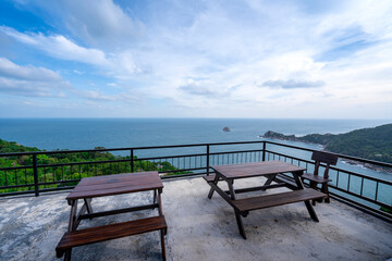 Fototapeta na wymiar wooden table on rooftop terrace at view point of blue sea coast, lanscape view from mountain peak at Koh Tao islands, Thailand