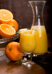 glass of fresh orange juice with fresh fruits on wooden