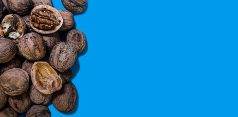 Walnuts whole and chopped on a blue background. Food.