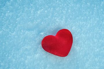 A red hot heart lies on the cold snow.