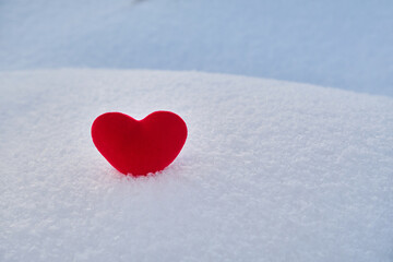 Fototapeta premium A red hot heart lies on the cold snow.