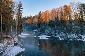 Fototapeta na wymiar Winter landscape the river in the forest at sunset. Winter sunset rural river landscape.