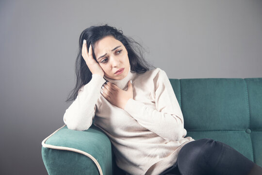 Ill Woman Sitting On The Sofa