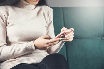 woman using smartphone sitting on sofa