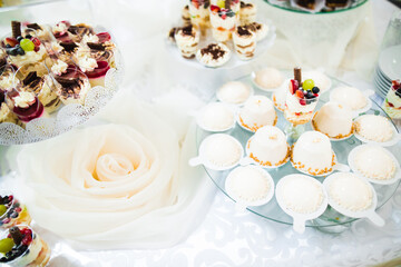 Delicious and tasty dessert table with cupcakes and shots at reception closeup