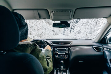 Man drives a car on snow winter road.