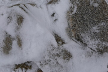 Ein abstrakter Hintergrund in grau-weiß. Granit und Schnee.