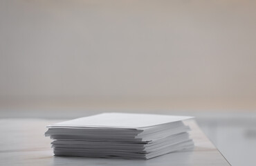 Stack of blank paper sheets on table in office, closeup