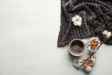 Flat lay composition with hot drink and warm plaid on white wooden table, space for text