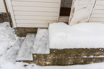 Concrete porch cleared of snow in winter and open antique door, country house in winter