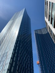 Naklejka premium Looking up at modern skyscrapers with a blue sky background. Incredible. modern architecture in Manchester England. 