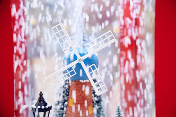 Toy Christmas red windmill with flying snow