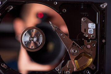 Component parts of a disassembled hard drive, close-up on a dark background.