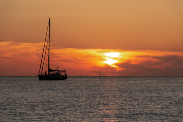 Seascape of silhouette of a sailing ship in the ocean at sunset