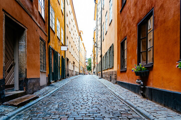 Fototapeta na wymiar Beautiful old cobblestoned street amidst old colorful houses in Gamla Stan Quarter in Stockholm