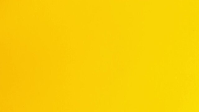 4k-Stop motion blue paper transformation to yellow on white background.
