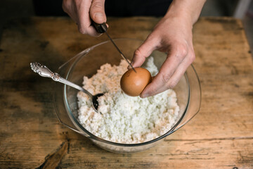 Breaks a chicken egg and adds to the curd