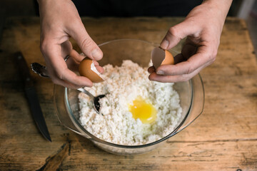 Breaks a chicken egg and adds to the curd