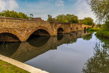 A view across the nine arch bridge over the River Nene in Thrapston, UK in springtime