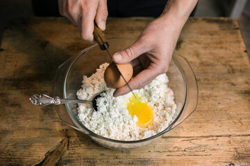 Breaks a chicken egg and adds to the curd