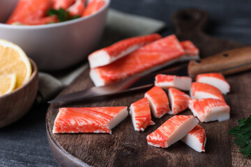 Fresh crab sticks, knife and lemon on grey table, closeup © New Africa