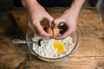 Breaks a chicken egg and adds to the curd