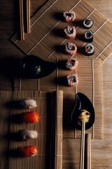 Sushi. Comida japonesa sobre esterilla. Foto de maki  y nigiri sushi con luz lateral.  Composición de comida asiática con jengibre y wasabi.