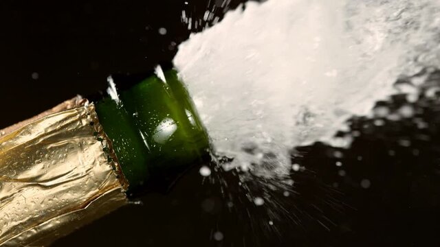 Super slow motion of Champagne explosion, opening champagne bottle closeup. Filmed on high speed cinema camera, 1000fps