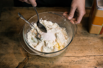 Adding sugar to curd with a spoon