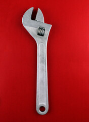 Metal adjustable wrench on red background. Great tool for mechanical work