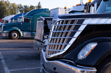 Various types of trucks in the parking lot next to the motorway. Truck stop.