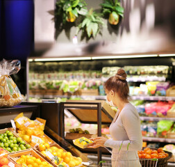  Supermarket shopping, face mask and gloves,woman buying vegetables at the market.
