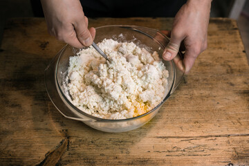 Stirring curd with chicken eggs. Cooking casseroles.