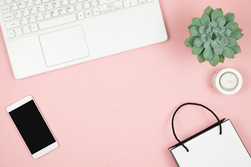 Shopping Online Concept. Womens phone and laptop on pink background. Top view, copy space.